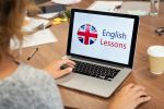 Woman learning english online Mature woman learning English online with computer at office. Laptop screen of woman displaying english lessons poster with British flag. Closeup of student using laptop doing online course on english.